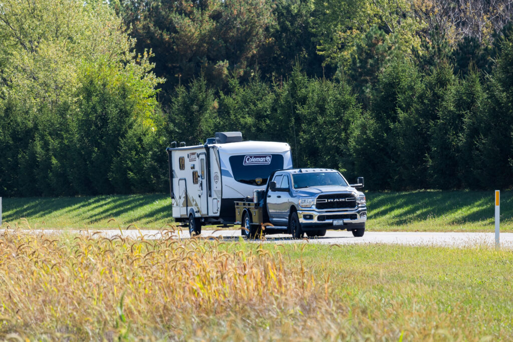 Transport driver hauling tow-away rv unit on highway. 